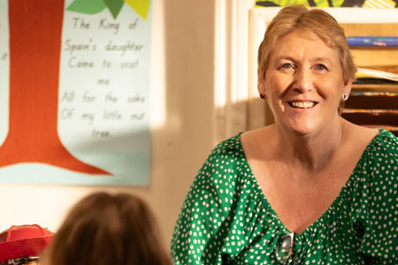 Karen, a teacher, engaging with kindy children in music and play.