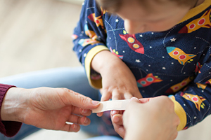 a bandage being placed on a child's finger